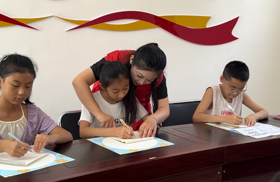 志愿者指导学生画脸谱。杨佳炜摄