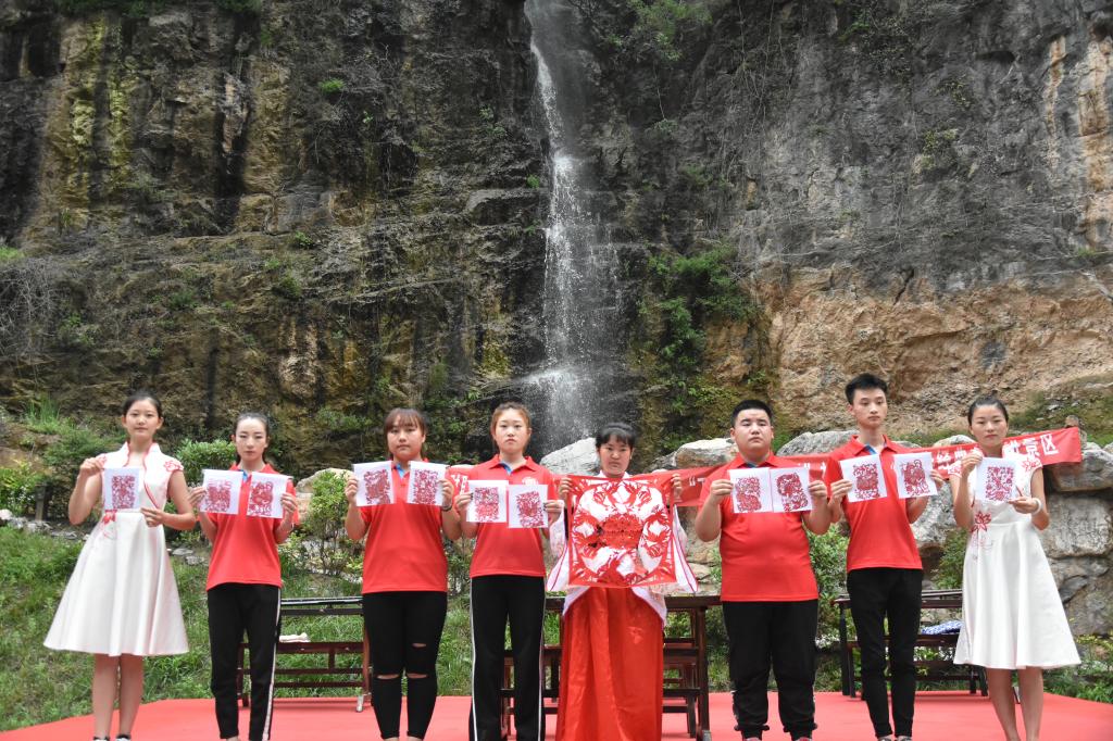 “镂金雕银”剪纸社马旭珍与“三下乡”志愿者共同展示我院学生剪纸作品